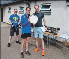  ?? 01_B21race26 ?? Organiser Peter Mackie of the Shettlesto­n Harriers presents the winners trophy to Tom Owens.