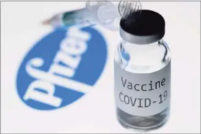  ?? Joel Saget / AFP via Getty Images ?? This illustrati­on picture taken in Paris on Nov. 23 shows a syringe and a bottle reading “COVID-19 Vaccine” next to the Pfizer company logo.