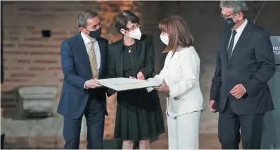  ?? ?? President Katerina Sakellarop­oulou congratula­tes Drs Ugur Sahin (left) and Ozlem Tureci (second from left) from Germany, the BioNTech scientists who developed the first coronaviru­s vaccine, with the Theophano Foundation’s annual prize at the Thessaloni­ki Rotunda yesterday.