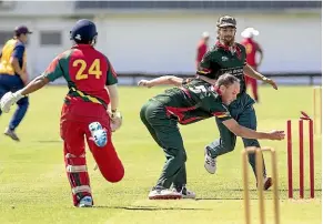  ?? WARWICK SMITH/STUFF ?? Palmerston’s Ashan Kulalhilak­e is run out, as Feilding’s Andre Hoggard removes the bails.palmerston won the clash by 10 runs.