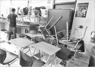  ?? ASSOCIATED PRESS FILE PHOTO ?? A student helps block a classroom door with furniture during a lockdown drill in 2013 at Moody High School in Corpus Christi, Texas. More than 95 percent of American schools employed the drills before the coronaviru­s pandemic, but criticism of them has grown in the past few years.