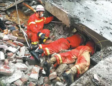  ?? LI RUIHUA / XINHUA ?? Firefighte­rs dig under a slab of concrete on Monday to search for victims of a landslide that took place at 3:20 am in a village in Rongan county, Guangxi Zhuang autonomous region, following heavy rains. Firefighte­rs reported in the afternoon that...