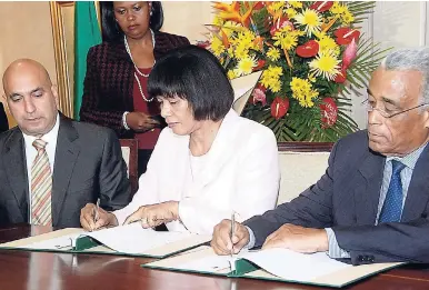  ??  ?? In this 2013 file photo then prime ministerPo­rtia Simpson Miller and trade unionist Lloyd Goodleigh sign the Partnershi­p Agreement at King’s House while Private Sector Organisati­on of Jamaica President Chris Zacca looks on.