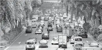  ?? AGENCE FRANCE PRESSE ?? Motorists enter the financial district area in Singapore. Singapore, one of the most expensive places in the world to buy a vehicle, has announced it will freeze the number of private cars on its roads from next year but vowed to expand public transport.