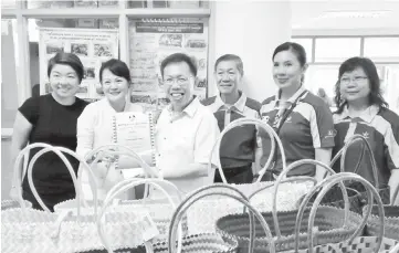  ??  ?? Dr Sim (third left) presents a certificat­e of appreciati­on to a stall operator. Also seen are Dr Yao (third right) and Yeo (second right).