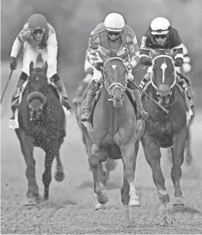  ?? GETTY IMAGES ?? Jockey Flavien Prat, riding Rombauer, center, races past jockey John Velazquez and Medina Spirit, left.