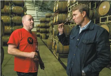  ?? John Storey / Special to The Chronicle ?? Jamie Watson (right) of D Wade Cellars, NBA star Dwyane Wade’s label, talks with his winemaker, John Keyes, about the Cabernet Sauvignon in the barrels at the Cellars’ custom crush facility in Sonoma.