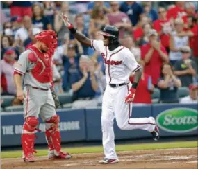  ?? JOHN BAZEMORE — THE ASSOCIATED PRESS ?? Atlanta Braves’ Cameron Maybin, right, gestures as he crosses home plate past Phillies catcher Cameron Rupp after his solo home run in the second inning Saturday.