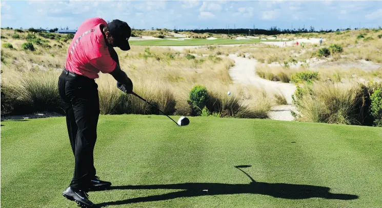  ?? DANTE CARRER / THE ASSOCIATED PRESS FILES ?? Tiger Woods tees off on the 14th hole during the Hero World Challenge in Nassau, Bahamas, last month. Woods says he is golfing without pain.