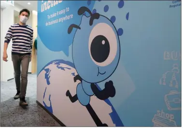  ??  ?? An employee walks past a graphic of the Ant Group’s mascot at the company’s office in Hong Kong. Ant Group has tangled with Chinese regulators for years as its operations have grown.
(AP file photo)