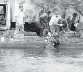  ?? PHOTOS BY JENNIFER LETT/SOUTH FLORIDA SUN SENTINEL ?? Industrial Divers Corporatio­n dive team enter a stench-ridden canal after a third pipe burst off of Southeast Second Street and Southeast Ninth Street in Fort Lauderdale on Saturday.