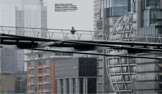  ?? Photo / AP ?? A lone runner crosses the Millennium Bridge in London as lockdown continues. The British government has just extended its lockdown powers.