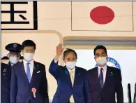  ??  ?? “I hope to develop a relationsh­ip of trust with President Biden,” Japanese Prime Minister Yoshihide Suga (center) said Thursday as he leaves Tokyo for the U.S. Suga will be the first foreign leader to have face-to-face talks with President Joe Biden.