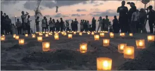  ??  ?? People light candles in Kula, Bali (above), while the bombings were also commemorat­ed at Westminste­r a decade on.