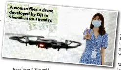  ??  ?? A woman flies a drone developed by
DJI in Shenzhen on Tuesday.
