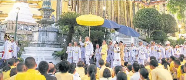  ?? POOL PHOTO ?? ROYAL BLESSING: His Majesty the King sprinkles holy water on people after a ceremony of changing the attire of the Emerald Buddha marking the start of the Buddhist Lent.