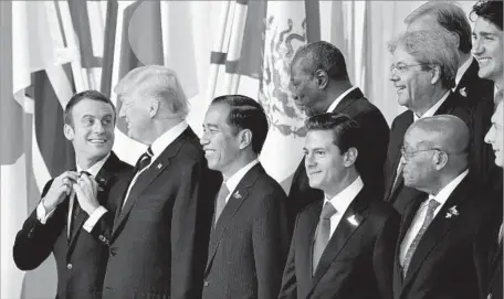  ?? Tobias Schwarz AFP/Getty Images ?? FRANCE’S Emmanuel Macron, left, with President Trump and other leaders in Hamburg, Germany, for the G-20 summit last week.