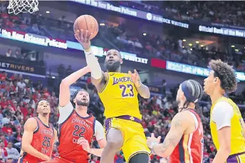  ?? — AFP photo ?? James (top) shoots against Larry Nance Jr. (second left) of the New Orleans Pelicans during the second half of a play-in tournament game at the Smoothie King Centre in New Orleans, Louisiana.