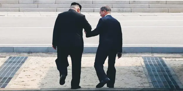  ??  ?? North Korean leader Kim Jong-un and the South’s president Moon Jae-in cross the military demarcatio­n line in a historic moment for the two nations