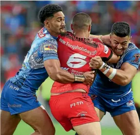  ??  ?? Tonga playmaker Tui Lolohea is greeted by some staunch Samoan defence in Hamilton.