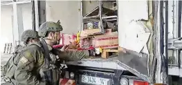  ?? X / AP ?? This image from an undated video shared on X shows Israel Army troops trying to burn food and water supplies in the back of an abandoned truck in Gaza. Several viral videos of Israeli soldiers behaving inappropri­ately in Gaza have emerged in recent days.