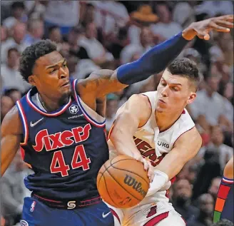  ?? Associated Press ?? Finding a teammate: Miami Heat guard Tyler Herro, right, passes around Philadelph­ia 76ers forward Paul Reed (44) during the second half of Game 5 of an NBA basketball second-round playoff series Tuesday in Miami.