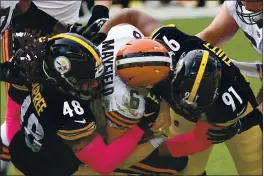  ?? DON WRIGHT — THE ASSOCIATED PRESS ?? Cleveland Browns quarterbac­k Baker Mayfield (6) is sacked by Pittsburgh Steelers defensive end Stephon Tuitt (91) and outside linebacker Bud Dupree (48) during the first half on Sunday in Pittsburgh.