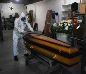  ?? AFP ?? Un trabajador del cementerio São Francisco Xavier, en Río de Janeiro, usa equipo de protección como medida preventiva.