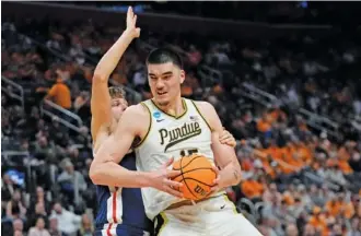  ?? AP PHOTO/PAUL SANCYA ?? Purdue center Zach Edey backs up Gonzaga forward Ben Gregg during an NCAA tournament Sweet 16 game Friday in Detroit. The 7-foot-4, 300-pound Edey’s massive size and classic low-post game have helped the Boilermake­rs reach the Elite Eight and win 32 games this season, but that type of play is all but extinct in the 3-point-happy NBA these days.