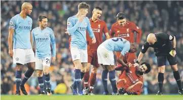  ??  ?? Liverpool’s Mohamed Salah reacts after being fouled by Manchester City’s Vincent Kompany (left). — Reuters photo