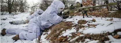  ?? ?? Preparatio­ns: Ukrainian snipers take part in military exercises as the nation braces for an invasion