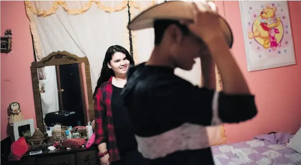  ?? PHOTOS: SARAH L. VOISIN / WASHINGTON POST ?? Lulu watches her brother Bryan try on a hat given to him by his grandmothe­r during their visit to their parents’ hometown, San Nicolas Solis.