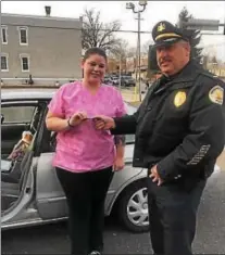  ?? PHOTO COURTESY OF THE PHOENIXVIL­LE POLICE DEPARTMENT ?? Acting Chief of Phoenixvil­le Police Thomas Sjostrom hands Tangie R., of Phoenixvil­le, a $100 bill as part of the Secret Santa initiative made possible by an anonymous resident. Police pulled over five drivers they thought could use the money this...
