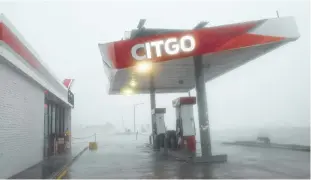  ??  ?? Hurricane Harvey brought heavy rain and strong winds to Galveston on Saturday, destroying the roof of a Citgo gas station. The dangerous conditions are keeping cruise ships and cargo ships from the island until further notice.