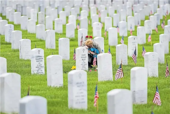  ?? EFE ?? Cruces y banderas. Una mujer visita la tumba de un familiar en el cementerio de Arlington, en Washington, este lunes, en el Día de los Caídos.