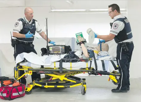  ?? PHOTOS: MICHAEL BELL ?? Paramedics Joe Trotter, left, and Kyle Parker, work with a practice mannequin at EMS Central.
