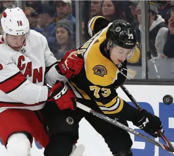  ?? AP File ?? ‘WE WANT TO PLAY’: Carolina Hurricanes' Ryan Dzingel battles with Bruins defenseman Charlie McAvoy during a game last year.