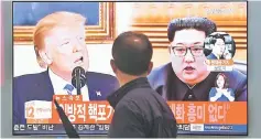  ??  ?? A man walks past a television news screen showing North Korean leader Kim (right) and Trump (left) at a railway station in Seoul. North Korea threatened to cancel the forthcomin­g summit between leader Jong Un and Trump if Washington seeks to push...
