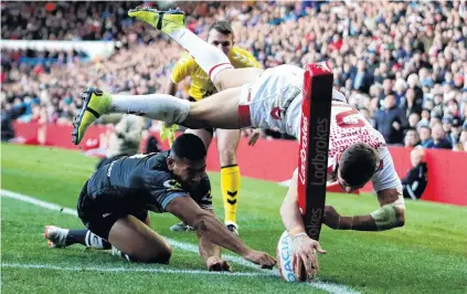  ?? PHOTO: GETTY IMAGES ?? Not quite . . . Tommy Makinson, of England, dots the ball down while being challenged by Jamayne Isaako, of New Zealand, during the Internatio­nal Series match between England and New Zealand at Elland Road in Leeds yesterday. Despite his effort, the try was disallowed.