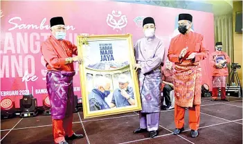  ??  ?? Bung Moktar (left) presenting Hajiji with a token of appreciati­on for gracing the celebratio­n. Also seen is Umno Sabah deputy chief Datuk Yakub Khan.