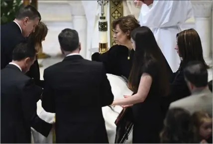  ?? TODD MCINTURF — DETROIT NEWS VIA THE ASSOCIATED PRESS POOL PHOTO ?? Family members, including mother Mary “Mia” Fraser, center right, place a pall on the casket of Brian Fraser as family members, friends and supporters gather during the funeral for Brian Fraser at St Paul on the Lake Catholic Church in Grosse Pointe Farms, Mich., on Saturday.