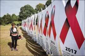  ?? STEVE SCHAEFER / SPECIAL TO THE AJC ?? Maureen Robertson-Randall looks over the HIV/AIDS historical milestone display during the 27th annual AIDS Walk Atlanta & 5K Run held last October in Piedmont Park.