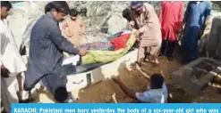  ?? — AFP ?? KARACHI: Pakistani men bury yesterday the body of a six-year-old girl who was raped and murdered.