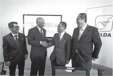  ?? — Gambar Bernama ?? MEGAT Zaharuddin (dua kiri) bersalaman dengan Ab Ghani (dua kanan) pada sidang media bersama Pengerusi FELDA di Menara Felda, Kuala Lumpur, semalam.