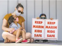  ??  ?? Beverly Chakrabart­y with her children, Leena, 3, and Kavish, 7, listen during a rally outside the Marin Office of Education to protest the district’s plans for inperson learning.