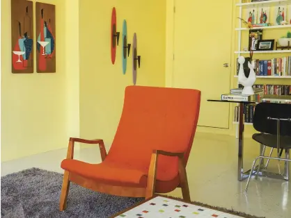  ??  ?? THE DEN POPS AND SIZZLES WITH COLOR. A 1959 MILO BAUGHMAN THAYER-COGGIN SOFA IS RADIANT IN SPRING GREEN MAHARAM UPHOLSTERY. A PAIR OF MILO BAUGHMAN MIDCENTURY SCOOP LOUNGE CHAIRS ARE VIBRANT IN ORANGE MAHARAM HOPSACK UPHOLSTERY.