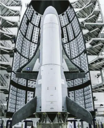  ??  ?? The X-37B is placed inside the nose cone of an Atlas V booster rocket before launching into space.