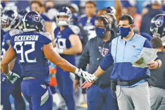  ?? AP PHOTO/WADE PAYNE ?? Tennessee Titans coach Mike Vrabel slaps hands with defensive end Matt Dickerson after a play against the Buffalo Bills in the first half Tuesday in Nashville. The Titans won 42-16 to reach 4-0.