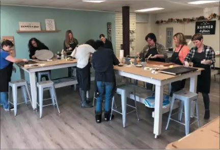  ?? SUBMITTED PHOTO ?? Customers work on projects at Hammer &amp; Stain in North Coventry, a DIY craft business where customers can make home decoration­s from wood. The business, at 692 W. Schuylkill Road, is owned by Lisa Scheidt.