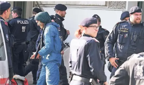  ?? FOTO: DPA ?? Eine Aktivistin steht zwischen Polizisten während einer Demonstrat­ion für Klimaschut­z in Wien. Dort soll es zu Gewalttate­n gekommen sein.